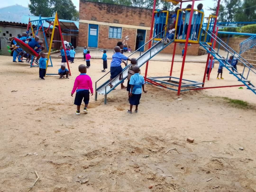 Élèves de maternelle en uniforme bleu jouant dans la cour de l’école de Janja